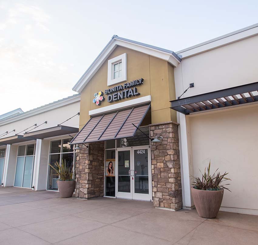 The exterior of Bonita Family Dental at 4424 Bonita Road in Bonita, CA, featuring the practice signage, stone-accented columns, and striped awning entrance