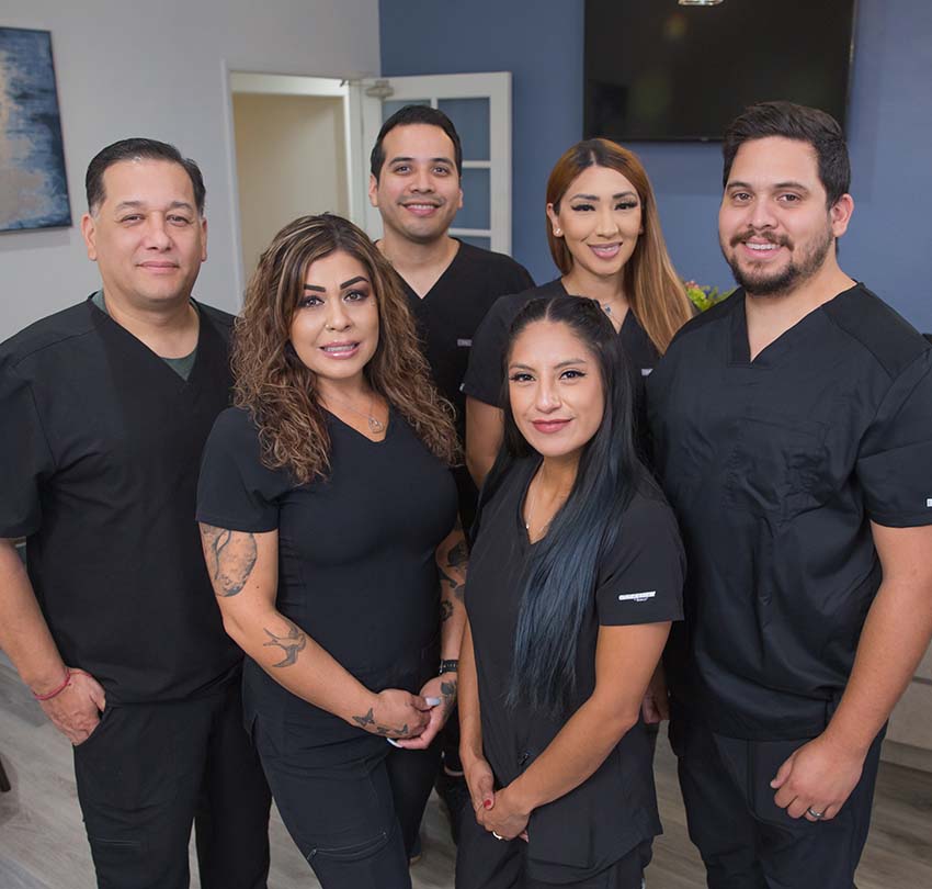 Six members of the Bonita Family Dental support team in matching black scrubs, gathered together inside the Bonita, CA dental office, ready to serve patients from Chula Vista, National City, and the broader South Bay area